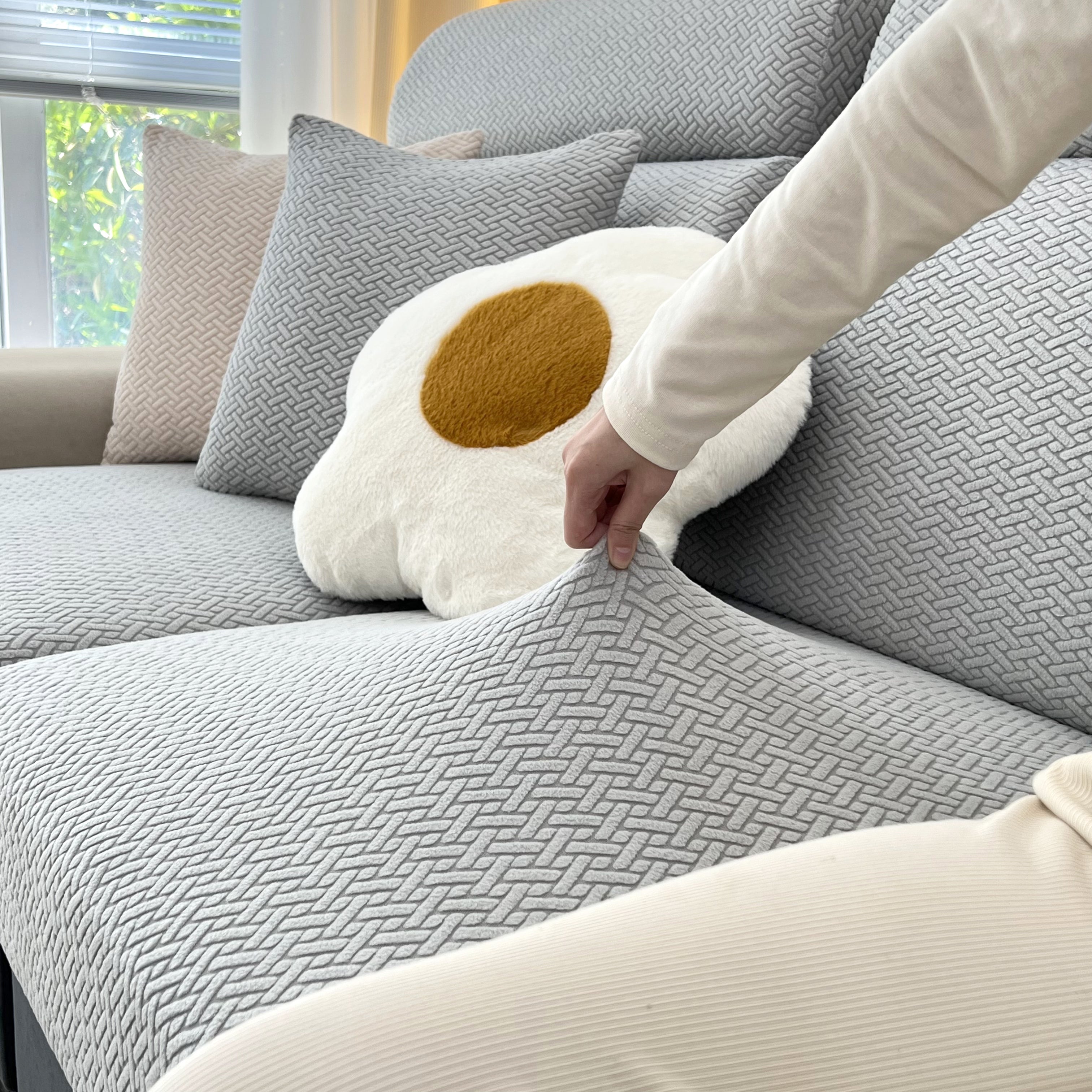 Stretchy FancySofas Classic bankhoes in de kleur Steel Grey, toont elasticiteit en pasvorm door de stof omhoog te trekken.